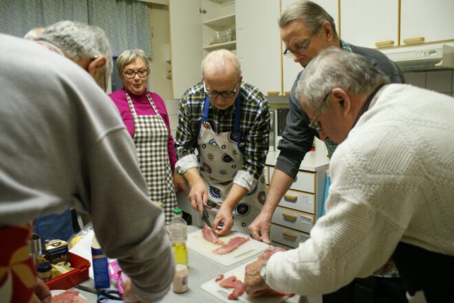 Marja-Leena Pohjanheimo tarkkailee, kun Risto Voittomäki, Risto Arve, Ossi Ojansivu ja Jaakko Santamäki (selin) valmistelevat possunlihaa. Kokkailemassa olivat myös Matti Leikkaa, Pekka Erkkilä, Reijo Hatanpää sekä Asko Oskura. Idea ikämiesten ruokakerhoon on kuulemma napattu Punkalaitumelta.