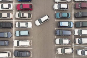 Regularity in car parking. A view to the carefully parked ranks of cars. Car navigation in the car park. Searching for vacant space for parking. The parking is jammed with cars. Parking problem.